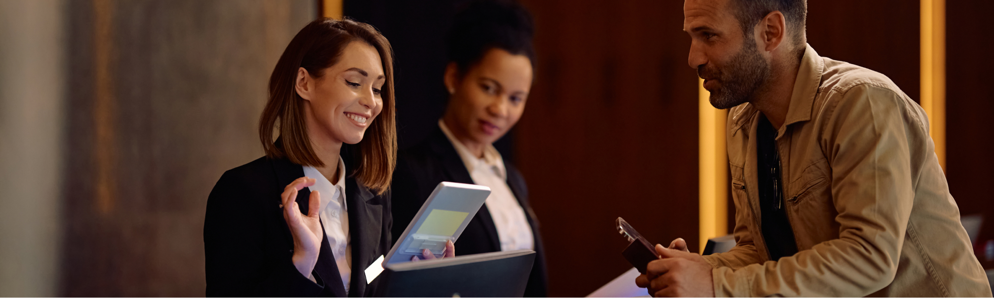 Rezeptionistin empfängt Hotelgäste beim Check-in