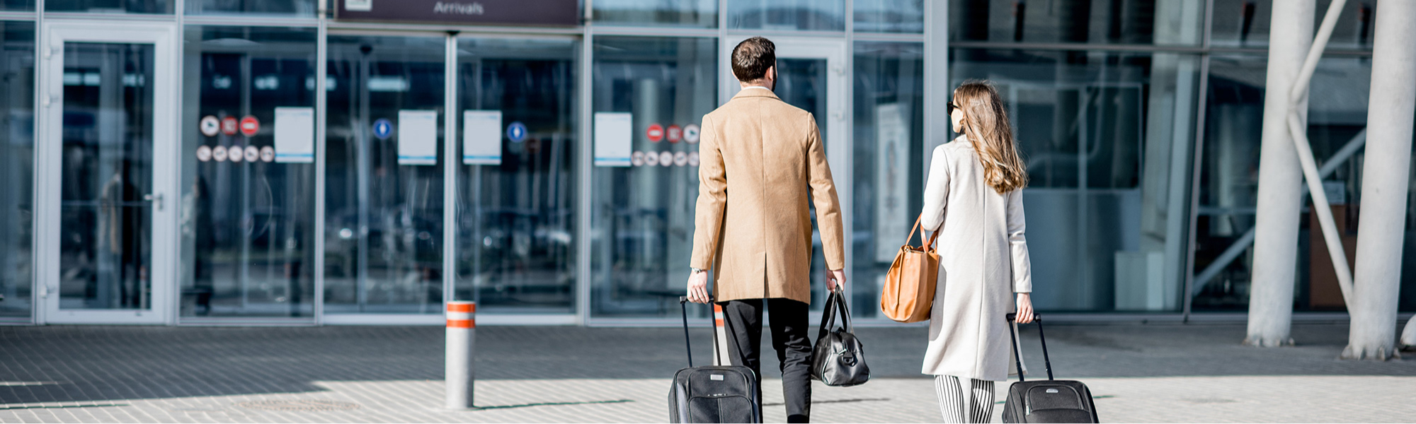 Zwei Personen beim Betreten eines Flughafengebäudes